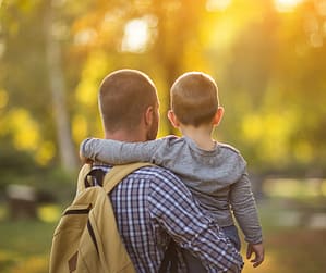 Single parent carrying a child, showing the Effects of Single Parenting on a Child and what helps them feel safe