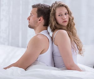 Couple sitting back-to-back at night, showing why marriages quietly die over time.