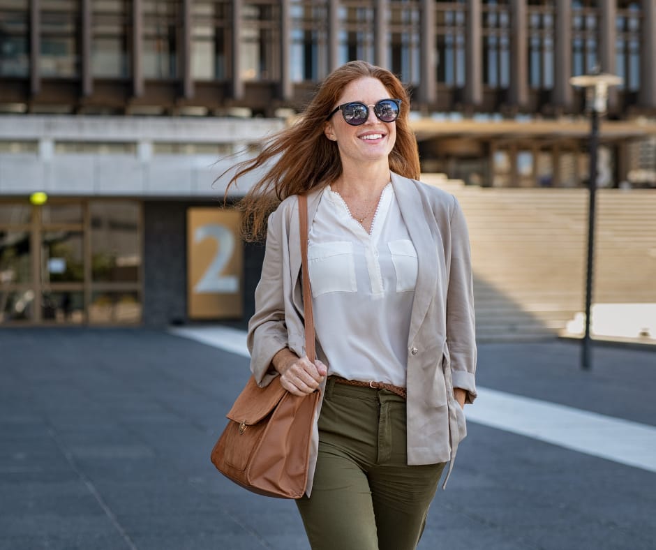 Professional woman walking near an office building, job loss did to her mind reset, layoff recovery, rebuild confidence, career restart after job loss.