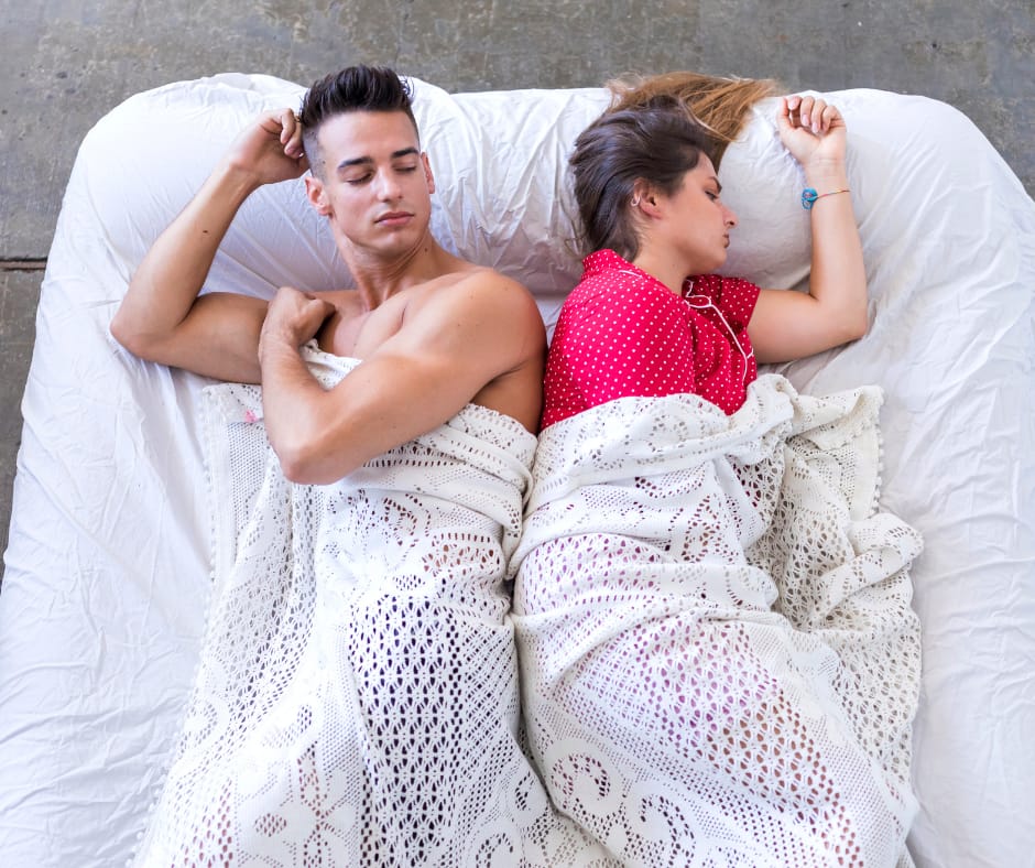 Husband and wife lying apart under blankets, a sign of distance, showing loss of sexual desire in marriage, that fits how to fix a sexless marriage and how to rekindle desire in a long-term marriage when mismatched libido in marriage hurts intimacy.